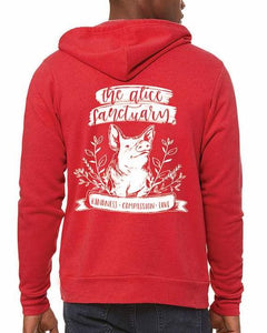 Man wearing a red hoodie with words on the back that say "The Alice Sanctuary - kindness, compassion, love" printed above a drawing of a pig.